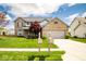 Charming two-story brick home featuring a well-manicured lawn, mature landscaping, and an attached two-car garage at 13331 Grouse Point Trl, Carmel, IN 46033