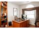Bright office with a large window, wooden desk, and built-in bookshelves at 13331 Grouse Point Trl, Carmel, IN 46033