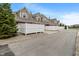 Townhomes with brick and siding feature a rear garages, white fence, and mature landscaping at 1352 Middlebury Dr, Westfield, IN 46074