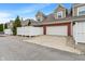 Townhomes with brick and siding feature a rear garages, white fence, and mature landscaping at 1352 Middlebury Dr, Westfield, IN 46074