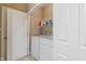 Well-lit laundry room features a white washer, dryer, and storage shelf for cleaning supplies at 1352 Middlebury Dr, Westfield, IN 46074
