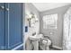 Compact bathroom featuring a pedestal sink, wall sconces and a window with natural light at 1412 Wallace Ave, Indianapolis, IN 46201