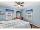 A cozy bedroom with blue walls and a ceiling fan offers a relaxing ambiance at 1412 Wallace Ave, Indianapolis, IN 46201