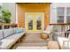 Inviting back porch with seating, colorful pillows, and yellow doors overlooking a wooden deck at 1453 English Ave, Indianapolis, IN 46201