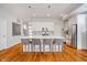 Kitchen with white cabinets, stainless steel appliances, an island with bar stools and wood floors at 1453 English Ave, Indianapolis, IN 46201