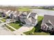 Aerial view of a home with a lush lawn, landscaping, and a view of a neighborhood pond at 15986 Bugle Ridge Dr, Noblesville, IN 46060
