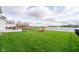Lush backyard with manicured lawn, patio, and lake views provides a serene outdoor retreat at 15986 Bugle Ridge Dr, Noblesville, IN 46060