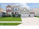 Inviting two-story home featuring a well-manicured lawn and a charming front porch with rocking chairs at 15986 Bugle Ridge Dr, Noblesville, IN 46060