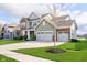 Attractive two-story house with a large driveway and a well-maintained lawn with a young tree at 15986 Bugle Ridge Dr, Noblesville, IN 46060