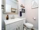 Stylish powder room with gray vanity, modern faucet, and decorative mirror and shelving at 15986 Bugle Ridge Dr, Noblesville, IN 46060
