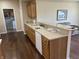 Kitchen with long countertop and bar seating, hardwood floors, and view to additional living space at 160 Bay Ridge Dr, Pendleton, IN 46064
