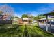 A well-manicured backyard with green grass, mature trees, and a brick home at 1733 N Spencer Ave, Indianapolis, IN 46218