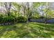Expansive backyard featuring mature trees, lush green grass, and a privacy fence at 1733 N Spencer Ave, Indianapolis, IN 46218