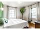 Bright bedroom with hardwood floors, two windows with curtains, a houseplant and a double bed at 1733 N Spencer Ave, Indianapolis, IN 46218