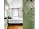 Bright bedroom with green accent wall, hardwood floors, and natural light from the window at 1733 N Spencer Ave, Indianapolis, IN 46218
