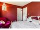 Cozy red bedroom with decorative light fixture, fuchsia chair, and soft comforter at 1733 N Spencer Ave, Indianapolis, IN 46218