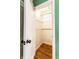 View into a small closet with wooden floors, white walls, and wooden rods for hanging clothing at 1733 N Spencer Ave, Indianapolis, IN 46218
