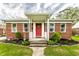 Inviting front porch with white railing, red door, and nicely landscaped garden bed at 1733 N Spencer Ave, Indianapolis, IN 46218