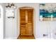 Hallway featuring hardwood flooring, white walls with artwork, and a wooden bifold door at 1733 N Spencer Ave, Indianapolis, IN 46218