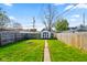 Spacious backyard with lush green grass, wooden fence, shed, and inviting fire pit perfect for outdoor enjoyment at 1917 Fletcher Ave, Indianapolis, IN 46203