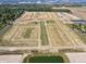 Aerial shot of a residential development with a mix of completed homes and empty lots, featuring ponds and tree-lined streets at 196 Aster Way, Greenfield, IN 46140