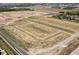 Aerial view of a new development with graded lots, street construction and ponds. New homes under construction at 196 Aster Way, Greenfield, IN 46140