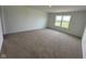 A spacious bedroom with neutral carpet and bright natural light from a large window at 196 Aster Way, Greenfield, IN 46140