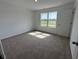 Bright bedroom featuring neutral carpet and a window with neighborhood views at 196 Aster Way, Greenfield, IN 46140