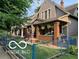 Classic two-story home featuring a cozy front porch, and green lawn at 2001 Hoyt Ave, Indianapolis, IN 46203