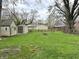 Well-manicured backyard featuring lush green grass, mature trees, and outbuildings at 210 Prairie Pkwy, Brownsburg, IN 46112