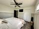 Bright bedroom featuring wainscotting, a ceiling fan, a TV, and an ample closet at 210 Prairie Pkwy, Brownsburg, IN 46112