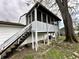 Exterior view of the home's rear screened porch and access stairs surrounded by lush landscaping at 210 Prairie Pkwy, Brownsburg, IN 46112