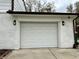 Attached garage featuring a white door, exterior lighting, and white brick at 210 Prairie Pkwy, Brownsburg, IN 46112