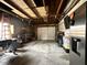 Spacious garage featuring a concrete floor, exposed ceiling, work bench, and storage at 210 Prairie Pkwy, Brownsburg, IN 46112