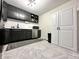 A modern kitchen showcases dark cabinetry, stainless steel appliances, and stylish gray flooring at 210 Prairie Pkwy, Brownsburg, IN 46112