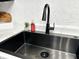 A modern black sink with a black faucet is set against a crisp white countertop and textured backsplash at 210 Prairie Pkwy, Brownsburg, IN 46112