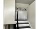 Minimalist staircase with white walls, black and white treads and risers, and modern art at 210 Prairie Pkwy, Brownsburg, IN 46112