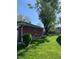 The backyard featuring a well-kept lawn, lush greenery, and mature trees at 2141 N Cole St, Indianapolis, IN 46224
