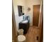 Bathroom features wood-look flooring, toilet and vanity with ample storage at 2141 N Cole St, Indianapolis, IN 46224