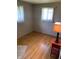 Bedroom with hardwood floors and light gray walls with two windows with sheer curtains at 2141 N Cole St, Indianapolis, IN 46224