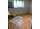 Neutral bedroom with hardwood floors, a sunny window with sheer curtains and an area rug at 2141 N Cole St, Indianapolis, IN 46224
