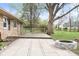 Stone patio featuring a fire pit and wooden deck surrounded by a spacious yard and mature trees at 225 Vali Ct, Carmel, IN 46280