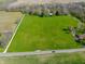 Expansive estate features a large green field, a red barn, two homes, and a long driveway at 2394 W 600 S, New Palestine, IN 46163