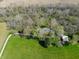 An aerial view showcases the home nestled amongst lush greenery and mature trees at 2394 W 600 S, New Palestine, IN 46163