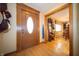Inviting foyer showcasing hardwood floors, a wood door with oval window, and dining room view at 2394 W 600 S, New Palestine, IN 46163
