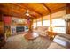 Cozy living room with a fireplace, exposed wood beams, and large windows to provide natural lighting at 2394 W 600 S, New Palestine, IN 46163
