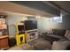 This basement features a media area with a large TV and an arcade game, perfect for entertainment at 263 Clark Ave, Beech Grove, IN 46107
