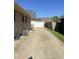 Exterior shot of a driveway leading to a detached garage with a white door at 263 Clark Ave, Beech Grove, IN 46107