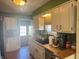 View of the cozy kitchen with white cabinets, a black sink and a door leading outside, and stainless steel appliances at 263 Clark Ave, Beech Grove, IN 46107