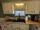 This kitchen features a black sink, complemented by light countertops and white cabinets, providing ample storage at 263 Clark Ave, Beech Grove, IN 46107